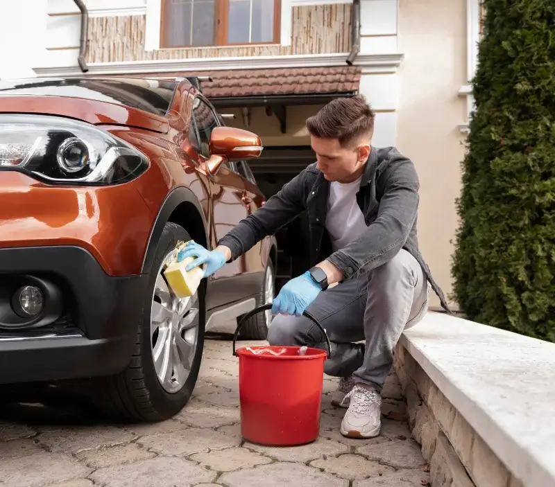 Lavage auto à domicile Parcoul-Chenaud : professionnel intervenant sur un véhicule